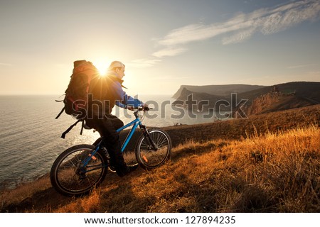 young man tourist on a bicycle traveling at night in the mountains