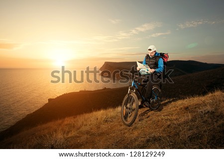 young man tourist on a bicycle traveling at night in the mountains