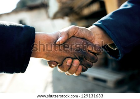 handshake of two workers at a factory close up