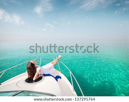 young beautiful female model lying on the deck of a yacht at sea. woman resting on the water
