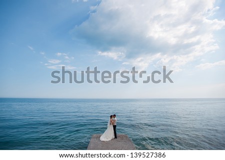 Young wedding couple hugging and kissing on the open seas. sea ??around the newlyweds