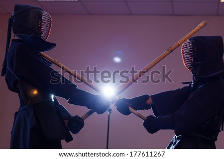 Two man kendoka fighting wooden sword. Japanese martial art of sword fighting.