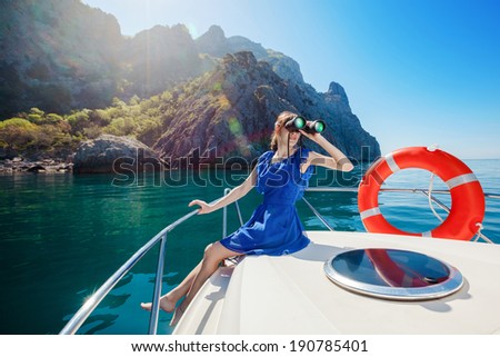 Happy woman sitting on the bow boat in the sea. Water activities.