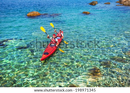 Couple men floating on a sea kayaking. Traveling by kayak outdoors on a summer day.