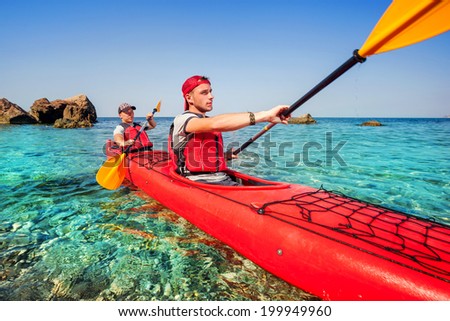 Men by sea kayaking. Traveling by kayak. Leisure activities on the water.
