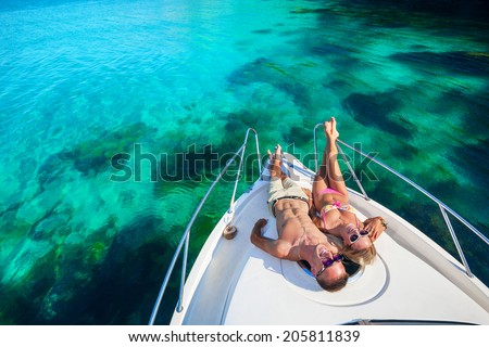 Happy couple lying on a boat at sea. Luxury vacation on a yacht in the islands.