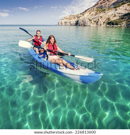 Kayaking. Young couple is sailing on a sea kayak. Sports and recreation on the water.