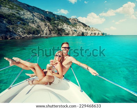 Happy couple relaxing on a boat at sea. Luxury holiday on a yacht.
