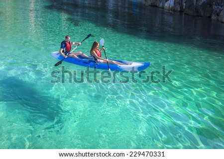 Kayaking. Young happy couple traveling by kayak. Activities on the water. Sailing on the sea.
