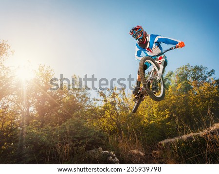 Downhill cycling. Man high jump on a mountain bike. Extreme sport.