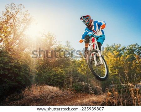 Downhill cycling. Man high jump on a mountain bike. Extreme sport.