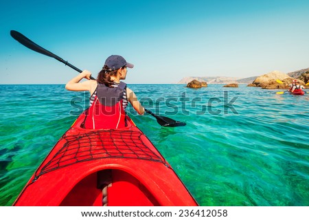 Kayaking. Woman floating on the sea kayak. Leisure activities on the sea. Canoeing.