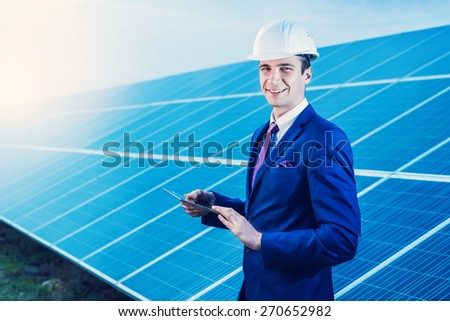 Solar panels. Engineer man with tablet on solar power station.
