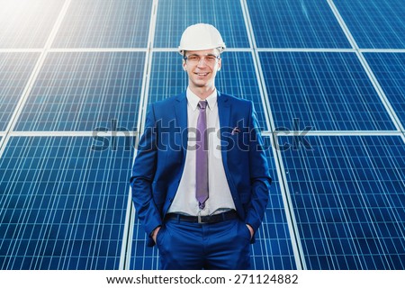 Portrait of a worker on a background of solar panels. Solar power plant. study of renewable energy power plants