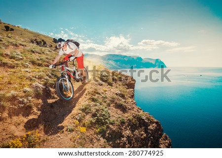 Downhill bike. Down from the mountain on a mountain bicycle. Extreme sport. Man riding outdoors lifestyle trail.