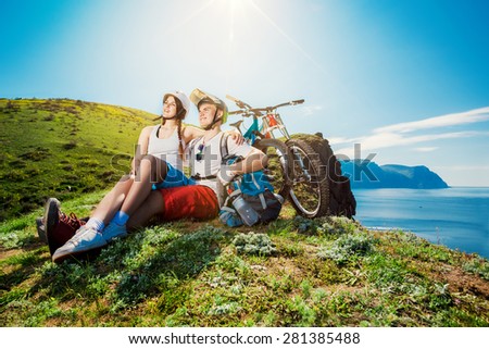 Young couple resting together on nature with the bike in the mountains. Youth sports.