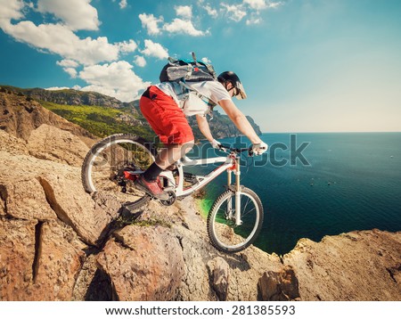 Downhill bike. Down from the mountain on a mountain bicycle on a rocky trail. Extreme sport. Man riding outdoors lifestyle.