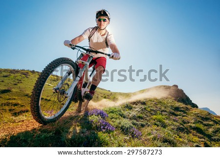 Mountain bike. Man riding bicycle on a dusty trail. Downhill.