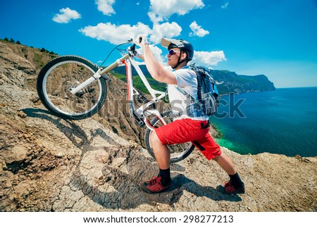 Man lifted the bike up the hill. Mountain Biking.Traveling by bicycle on the outdoors.