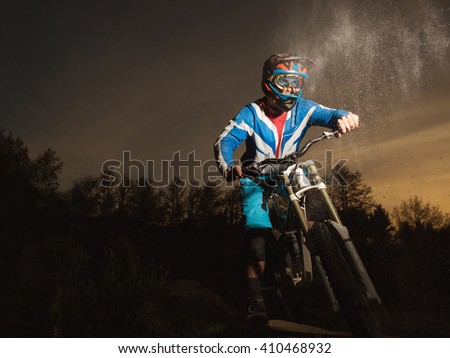Mountain bike evening. Downhill biking. Portrait of a professional cyclist in the helmet. MTB. Concept about people and sport.