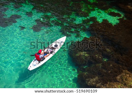 Fisherman catches a fish on a fishing kayak view from above.