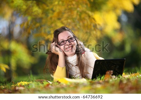Beautiful young woman with laptop in park