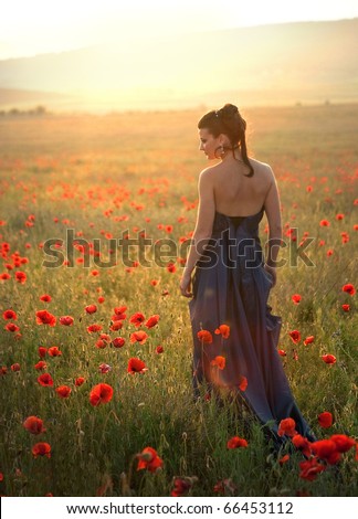 Girl stands in poppy field