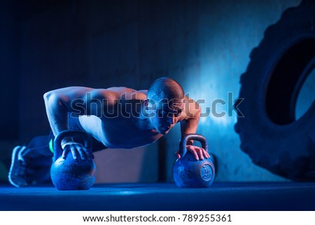 Man with kettlebell weights exercise in the fitness gym. Crossfit training workout. Sports functional training. Weightlifting workout. Sports, cross fit, fitness concept. Strength and motivation.