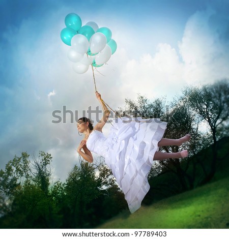 Beautiful bride in a wedding dress flying on balloons