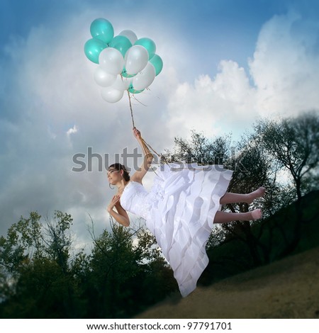 Beautiful bride in a wedding dress flying on balloons
