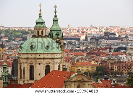 PRAGUE, CZECH REPUBLIC - SEPTEMBER 14: Landmark St Nicholas Catholic Church stands tall above typical red roofs and church spires of Mala Strana on September 14, 2012 in Prague.