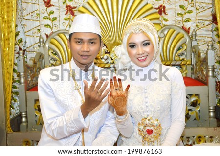 Indonesian bridal couples showing their wedding ring on fingers