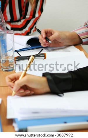 Business seminar situation, students with papers and pens in hands