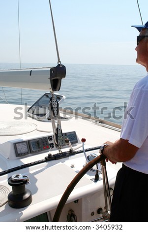 Captain beyond the yacht steering directing into the sea