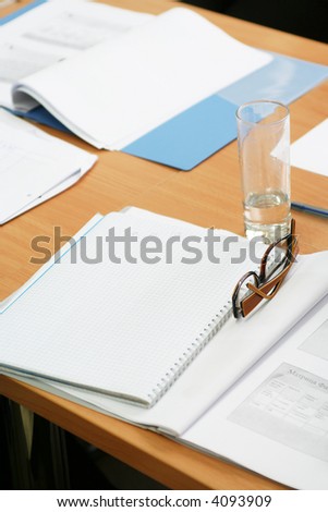 Glasses on the notebook. Empty table on seminar
