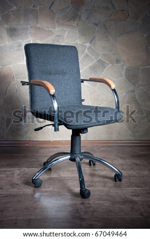 Office chair with armrests on a stone background