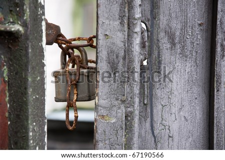 old padlock hangs on the old gate
