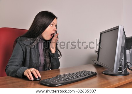 surprised woman sits at a computer