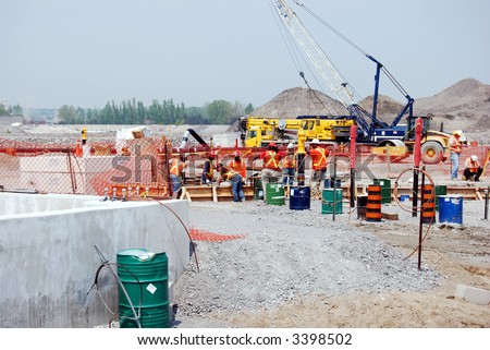 multi-cultural crew pour concrete on industrial construction site