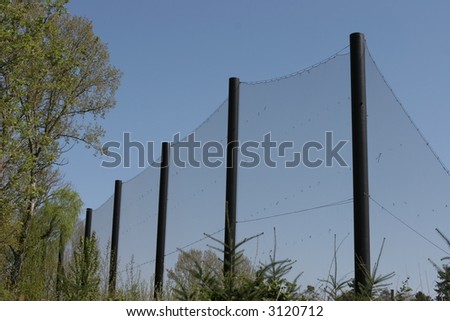 Tall mesh fence with metal poles