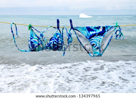 Bright swimsuit hanging on a rope on the background of the sea