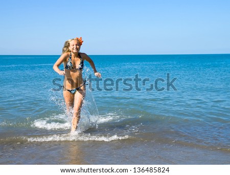 Laughing girl runs out of the sea