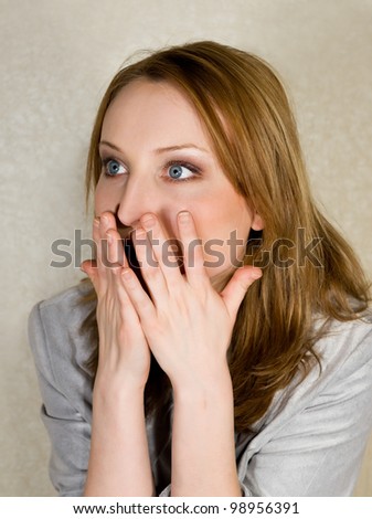 Portrait of scared girl closing mouth by hands