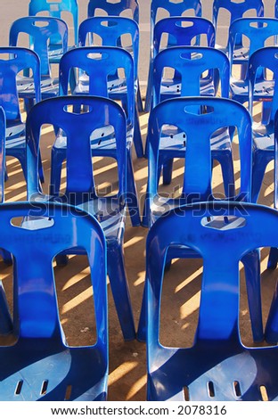 Lines of blue plastic chairs at a Thai temple