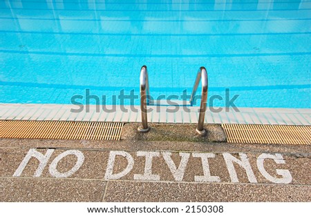 No diving sign at edge of swimming pool