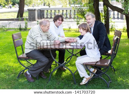 Four generations of men enjoying a sunny day in the park