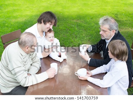 Four generations of one family drinking tea in the garden