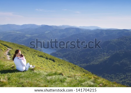 Young mother and her newborn daughter relaxing in the mountains