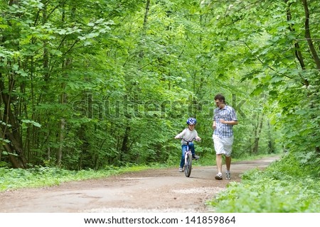 Young father teaching his son to ride a bike
