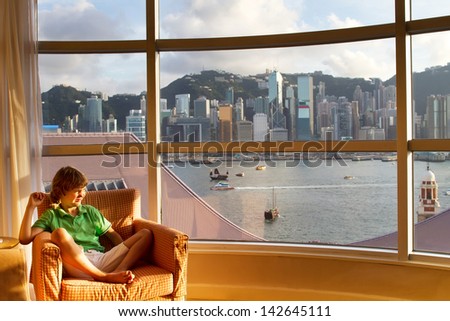 Little boy watching the view of the Hong Kong bay out of a hotel